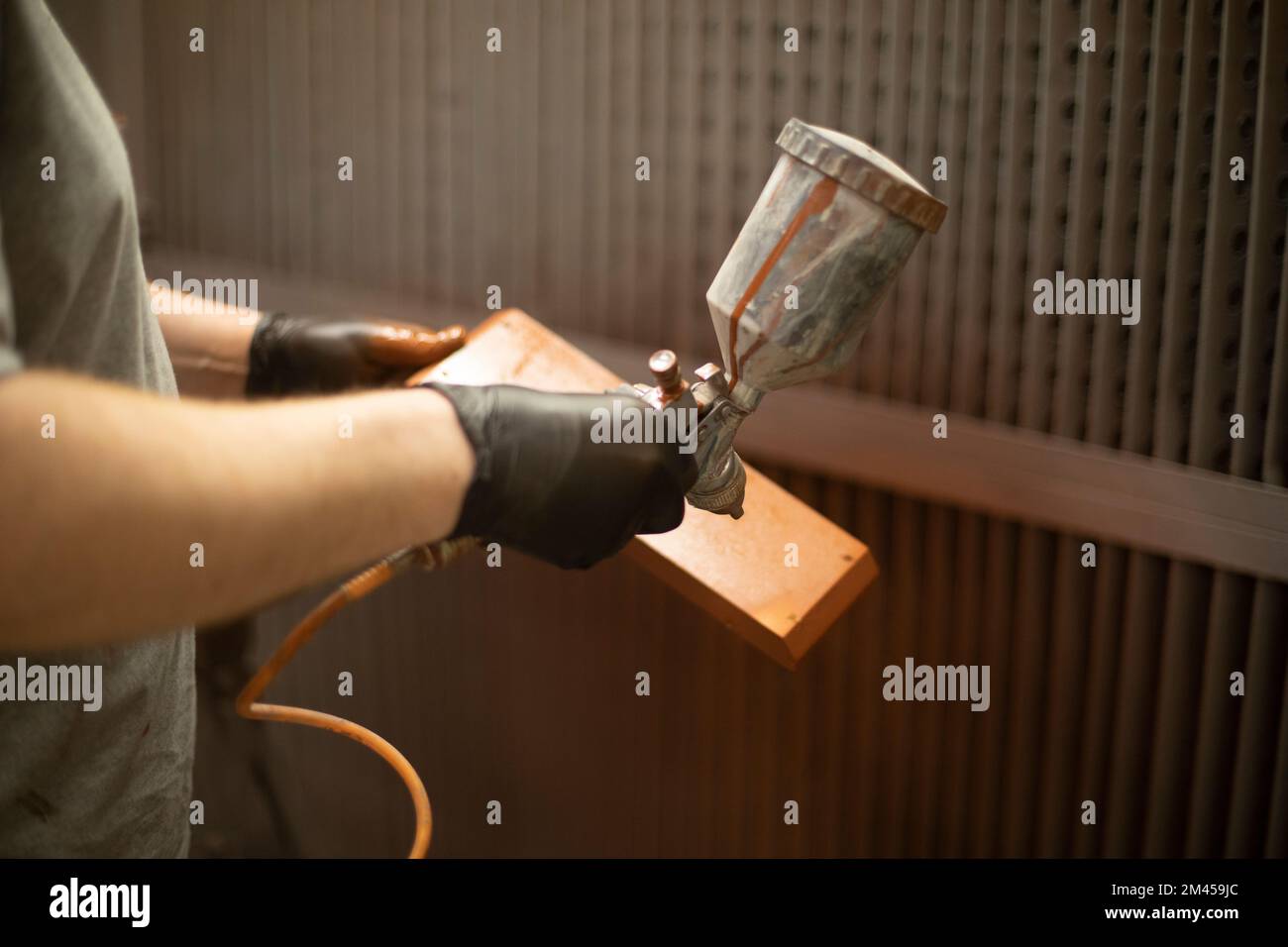 Painting wood. Spray paint. Spray gun in hand. Spray paint under