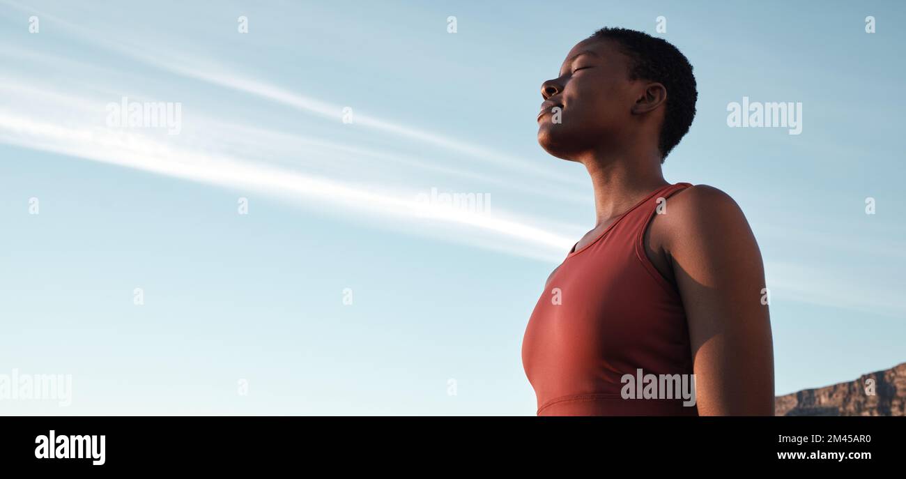 Fitness, breath and mockup with a sports black woman taking a break outdoor against a clear blue sky. Exercise, breathing and motivation with a female Stock Photo