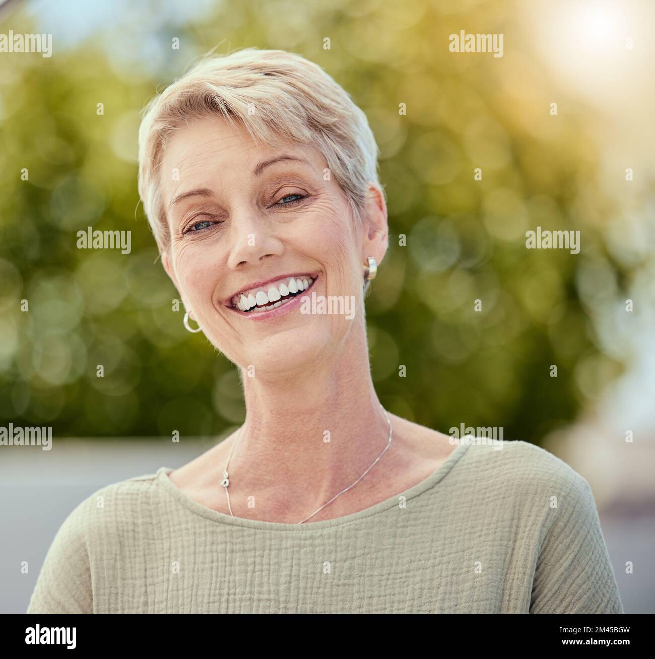 Senior woman, face and smile outdoor in retirement, environment and freedom in nature in Australia. Portrait, headshot and happy grandma in park for Stock Photo