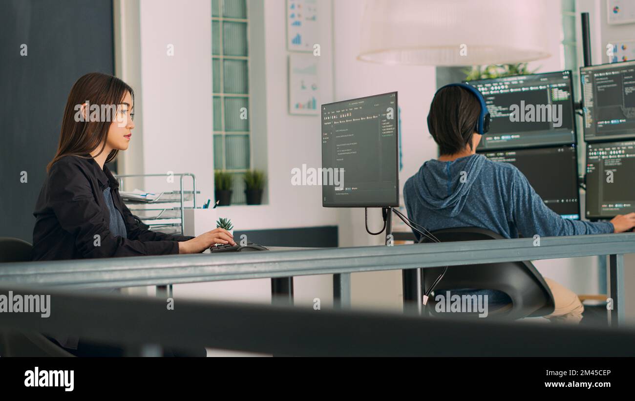 Database programer writing source code with coding language in it development room. App developer working on database programming with html script, computing big data. Handheld shot. Stock Photo
