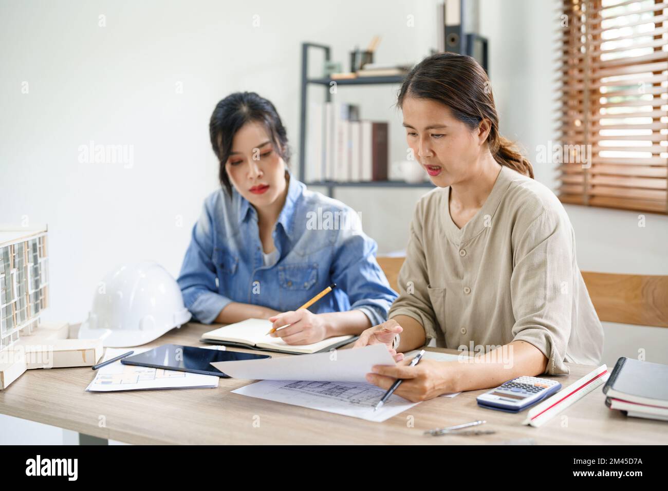 Engineering construction concept, Two female engineers is discussing construction and taking notes. Stock Photo