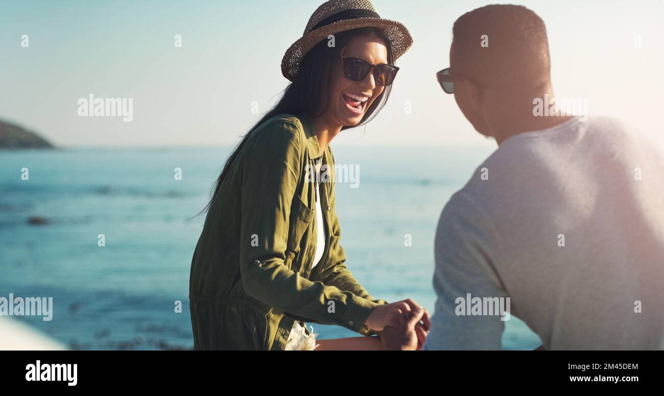 Love her and then make her laugh. a young couple making a stop at the beach while out on a road trip. Stock Photo