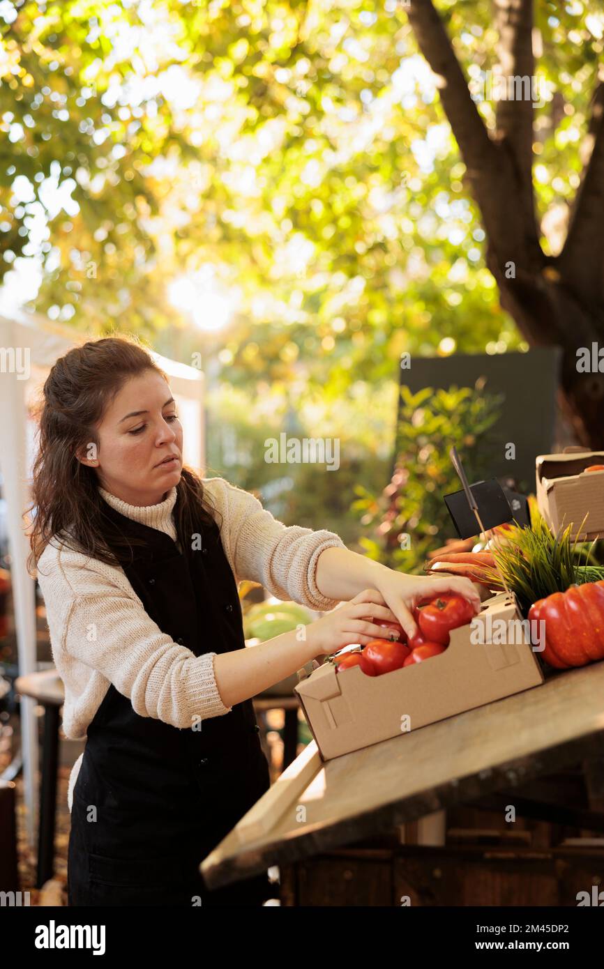 Female seller fresh fruits and vegetables stand owner preparing produce