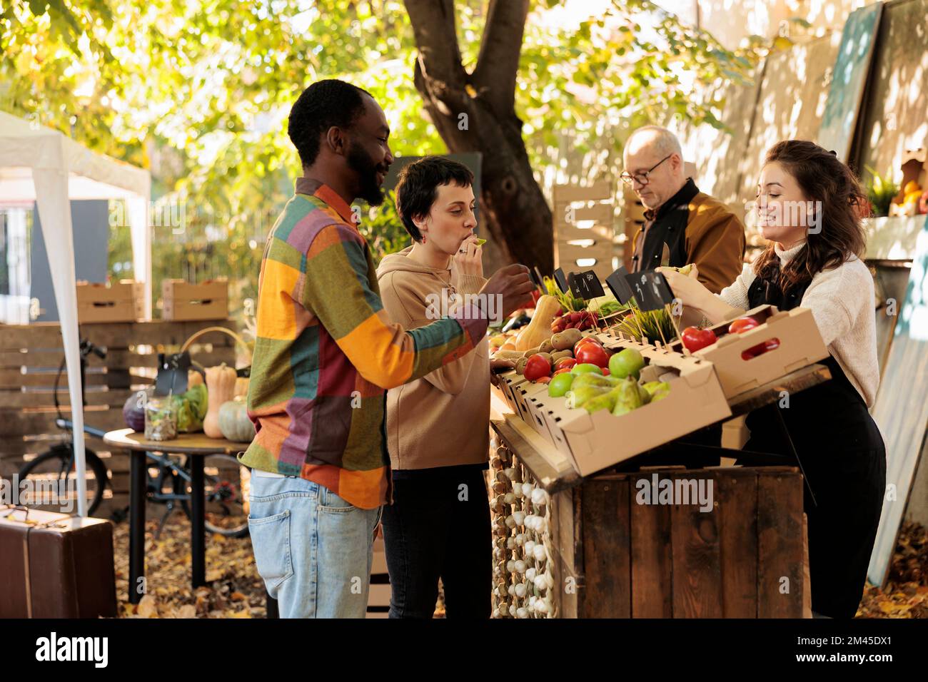 Man and woman receiving fruits samples at farmers market, checking
