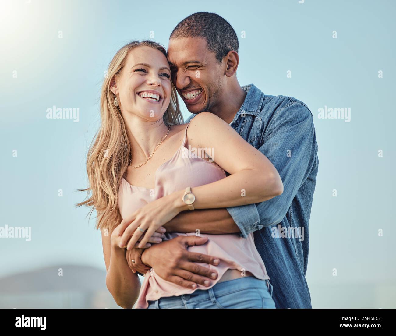 Love, diversity and couple hug on vacation, holiday or summer trip. Romantic, relax smile and happy man and woman hugging, embrace or cuddle, having Stock Photo