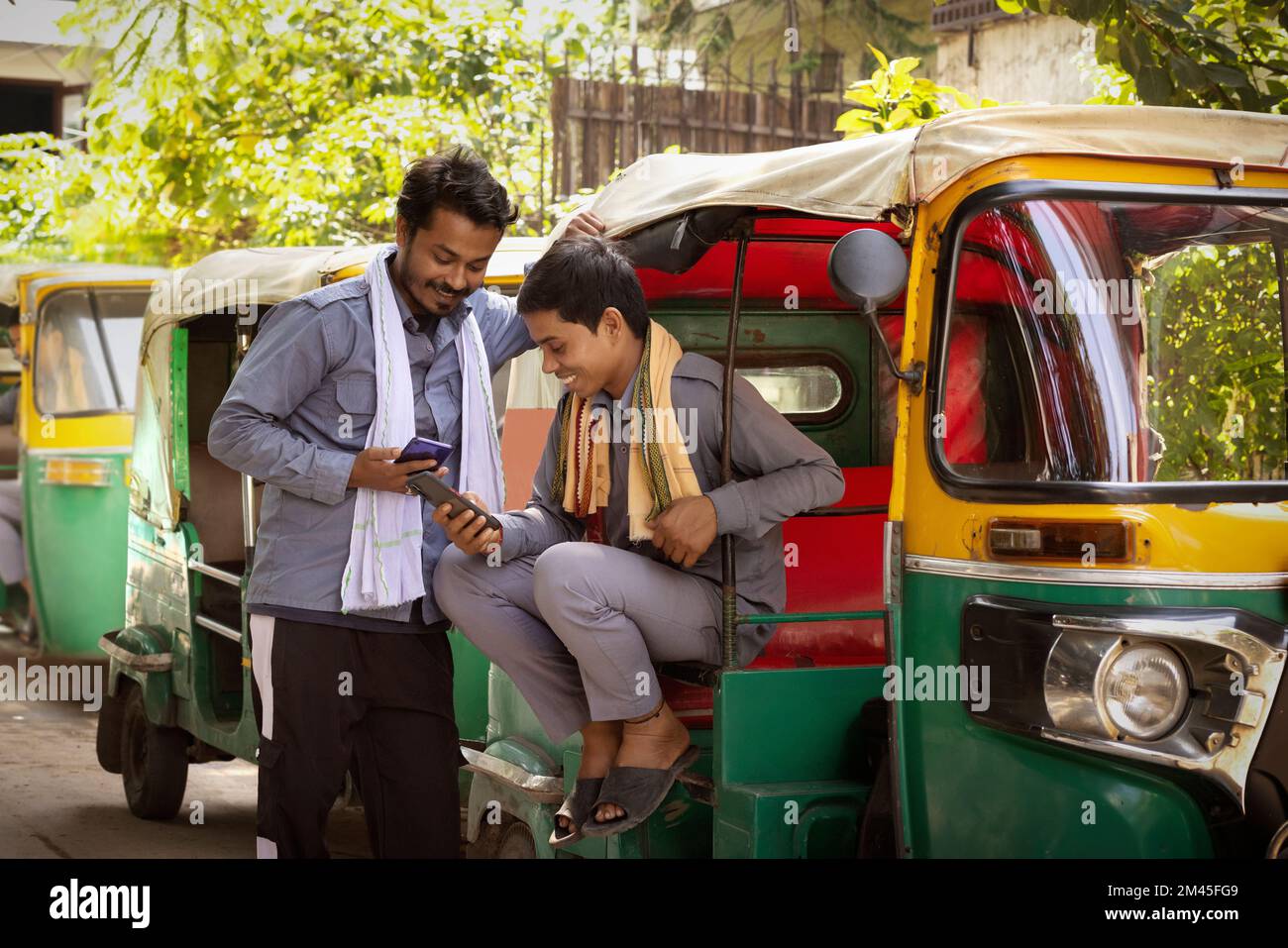 Auto rickshaw drivers using their mobile phones at auto stand Stock