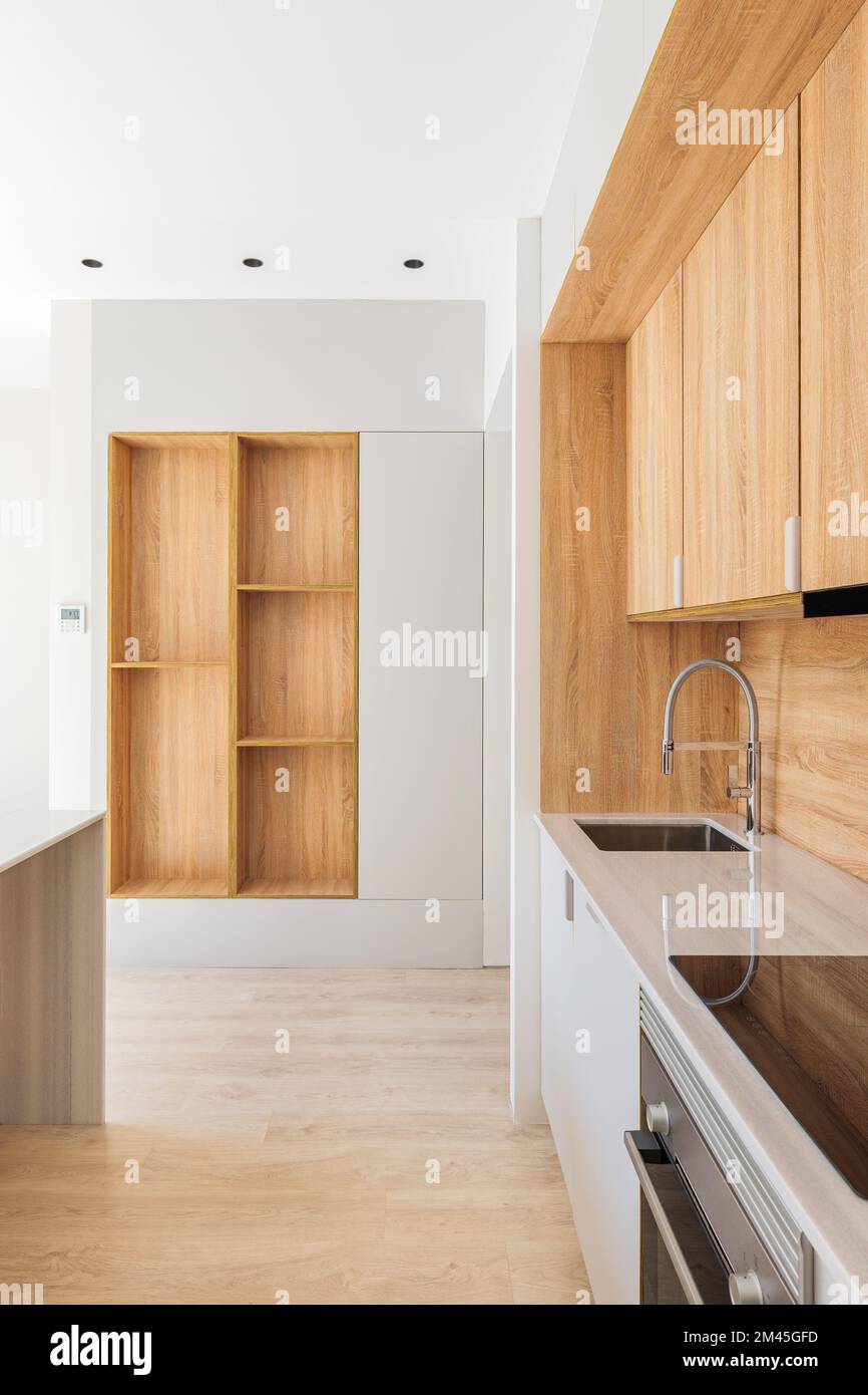 Along the wall is a modern kitchen with light wood The marble