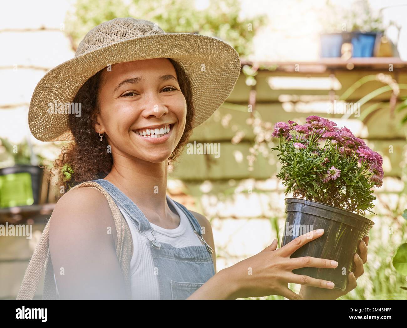 Face, flower pot and black woman shopping in floral shop or nursery. Portrait, sustainability and happy female gardener from South Africa with Stock Photo