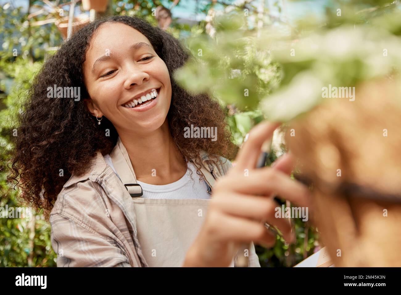 Plant shopping, happy and woman with a decision on flowers, retail garden and store for gardening product. Happiness, choice and business owner with Stock Photo