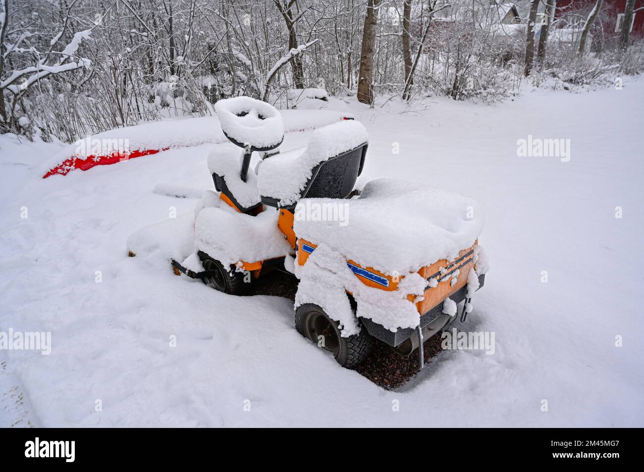 riding lawnmower standing outside covered in snow Stock Photo