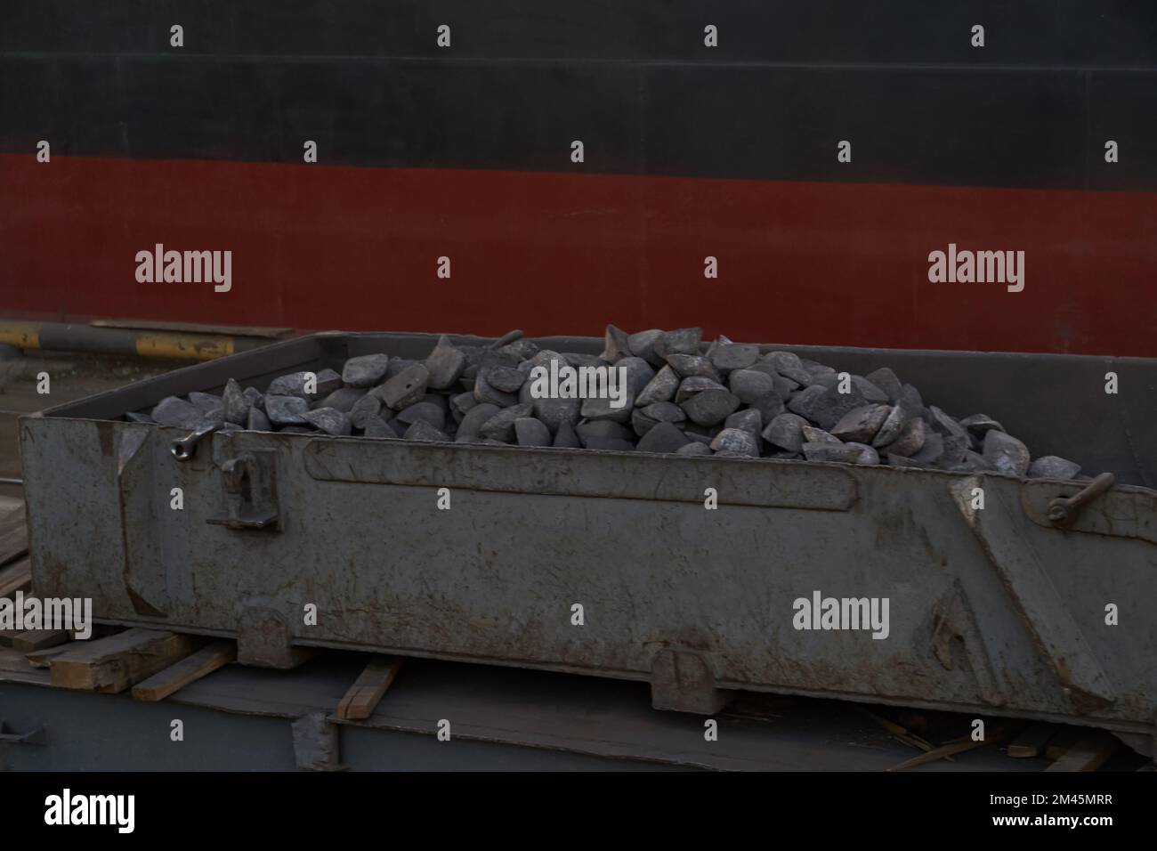 Loading cast iron ingots on ship bulk. Loading metal on ship