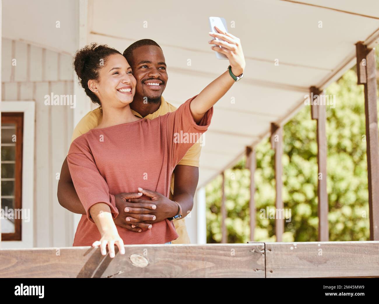 Love, phone selfie and black couple in home by balcony, bonding and