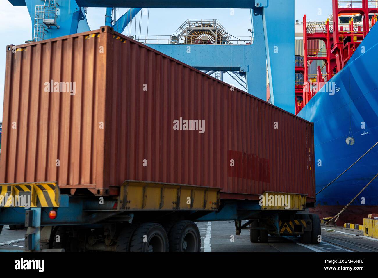 Port container terminal with container ship in background and brown ...
