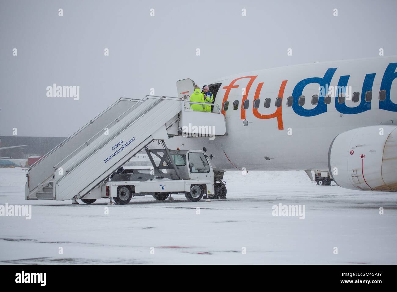 Odessa, Ukraine - CIRCA 2018: Passenger plane Fly Dubai at airport in winter in blizzard. Landing passengers in airliner in winter during snowstorm. M Stock Photo