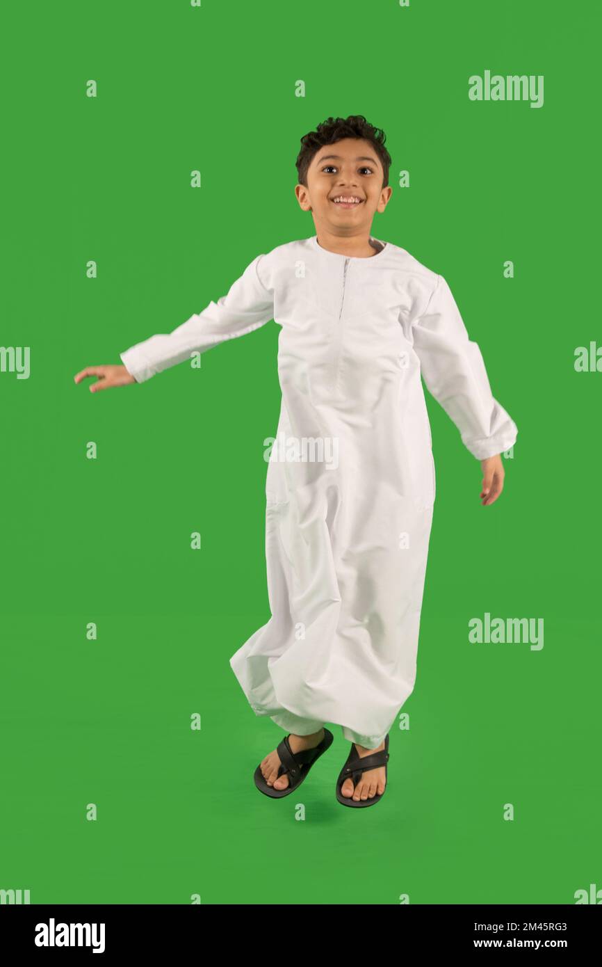 Arab boy jumping with arms outstretched. Stock Photo