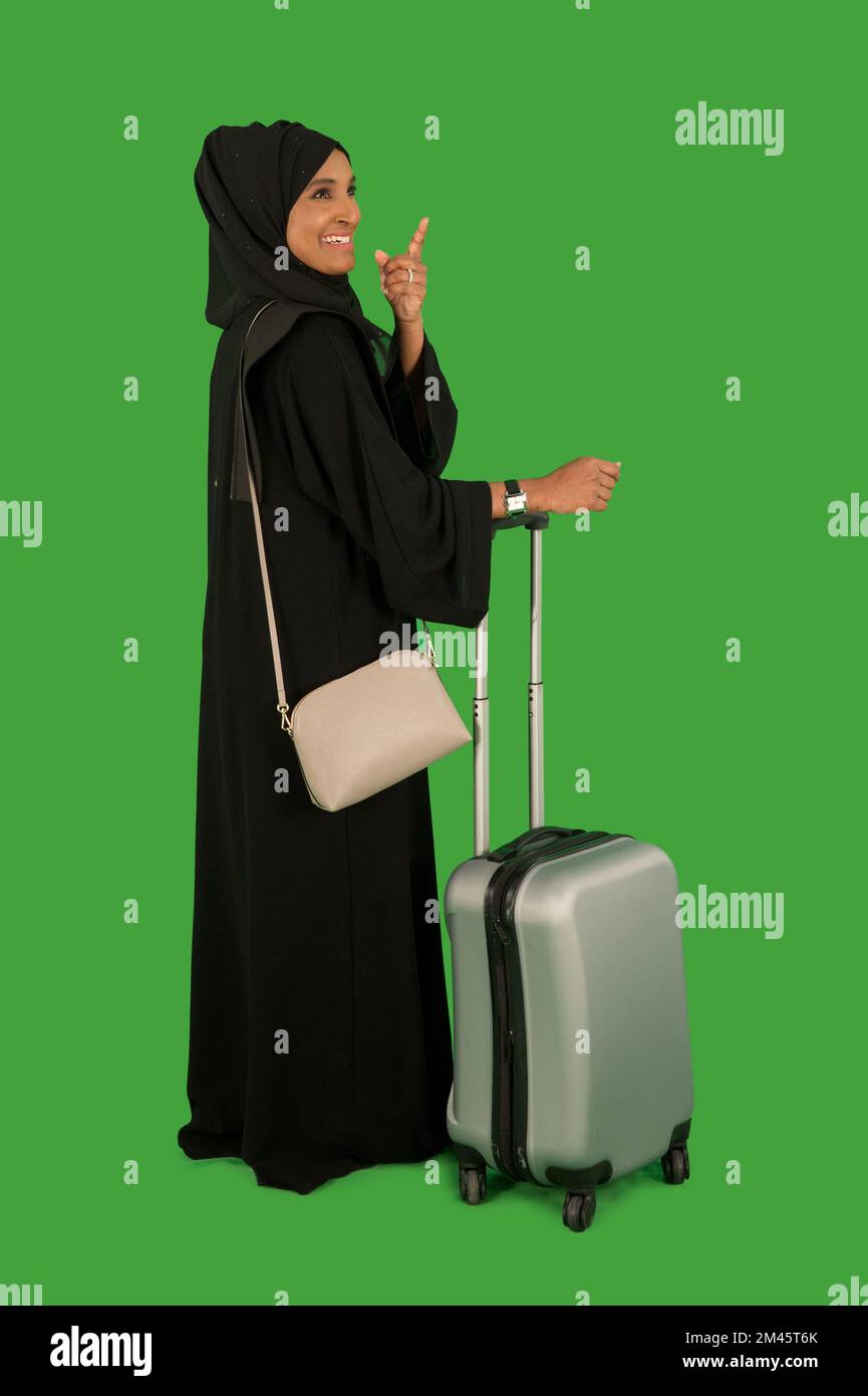 Emirati woman carrying a suitcase Stock Photo