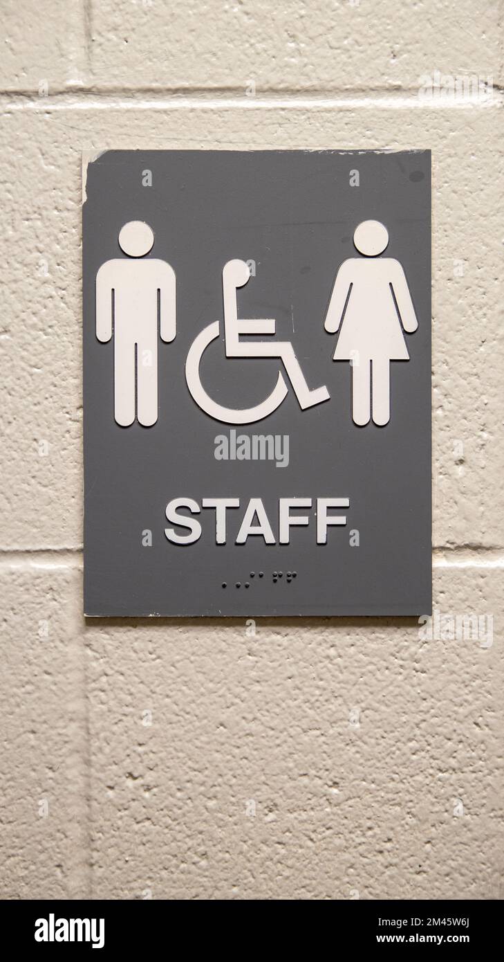 A closeup of staff restroom sign hanging on a white wall Stock Photo