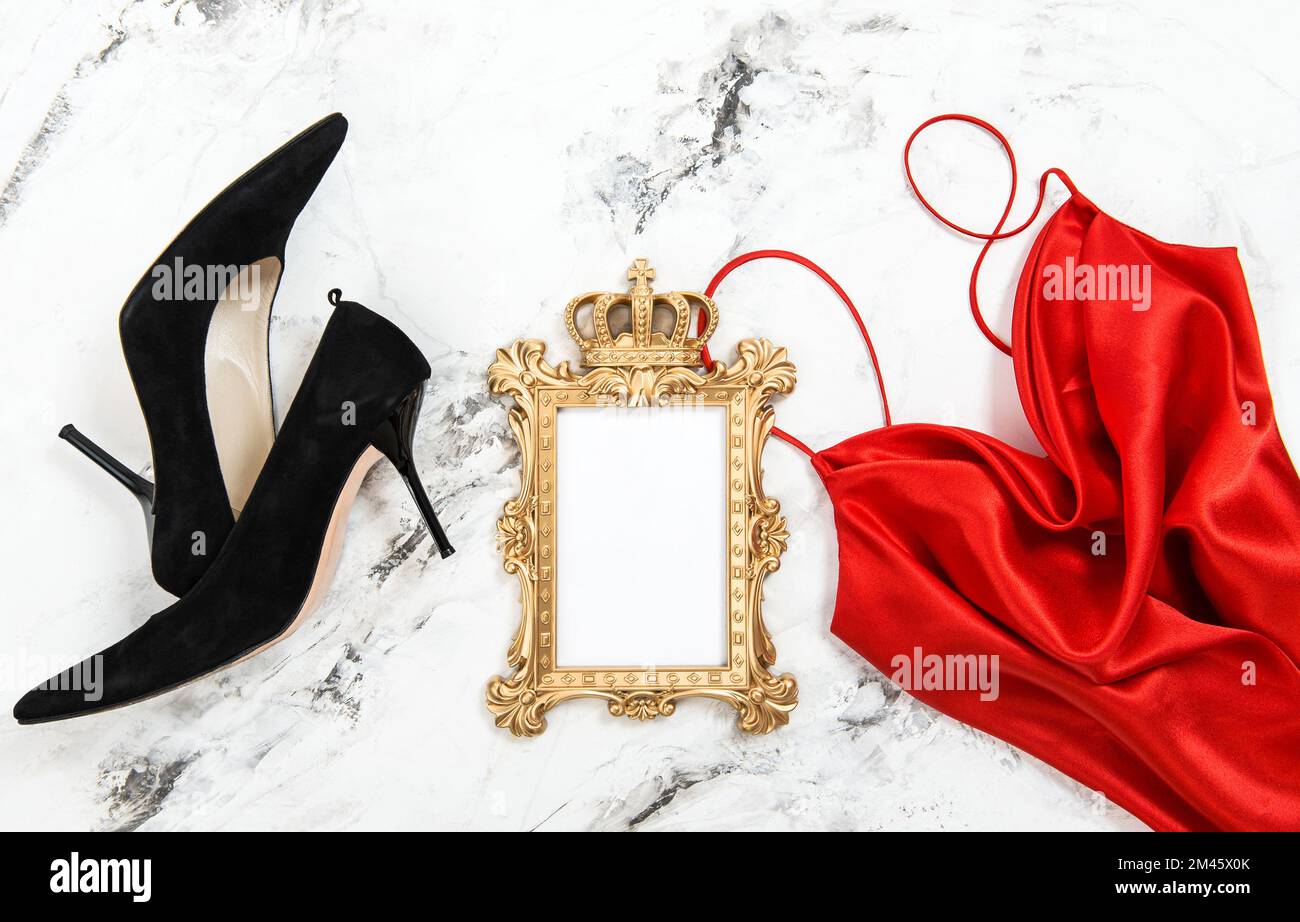 Fashion background. Red dress black high heels golden picture frame Stock Photo
