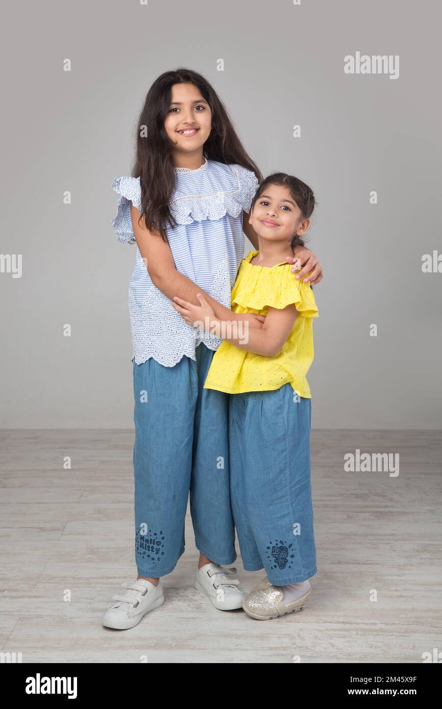 Two girls happily hugging each other. Stock Photo