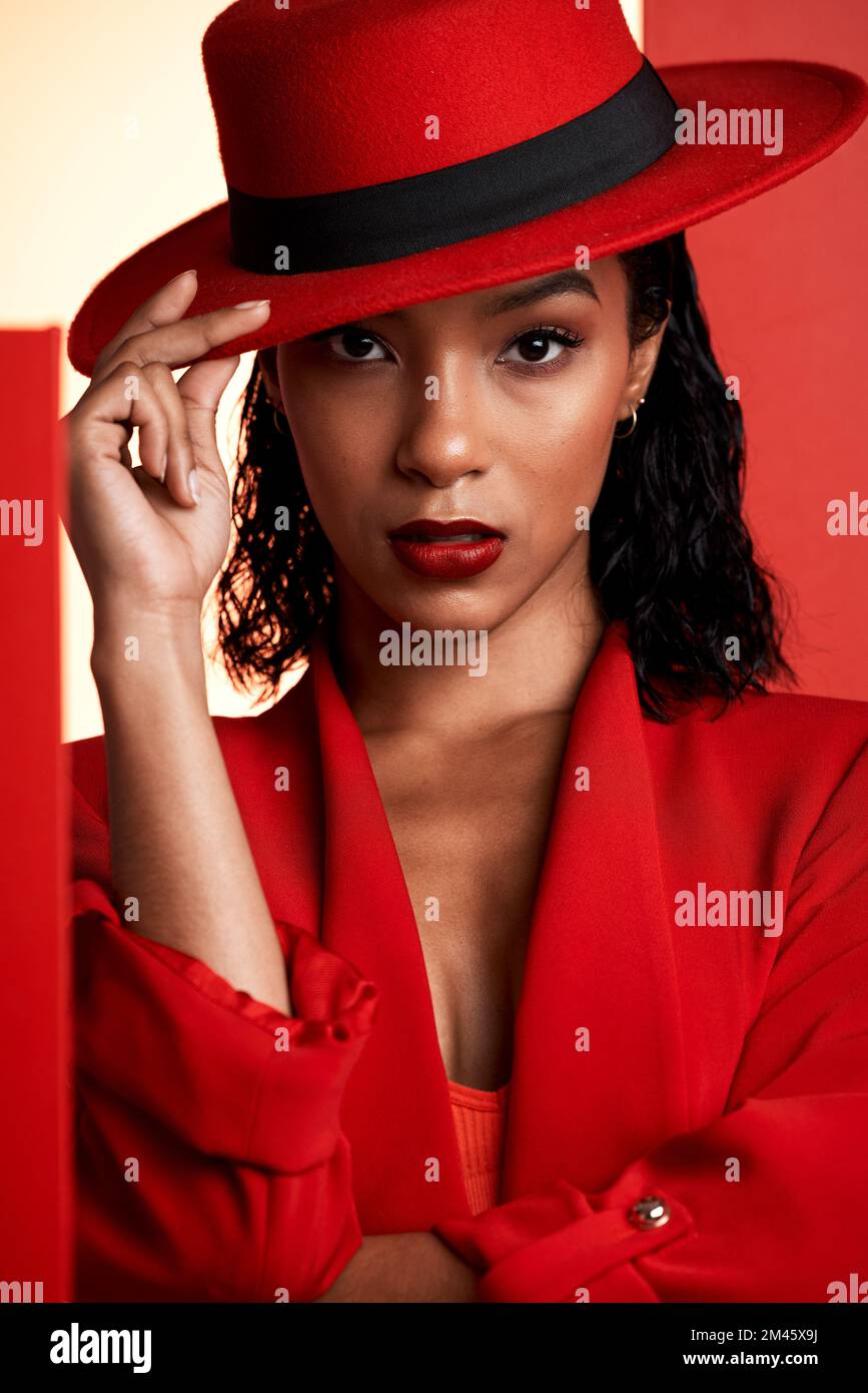 Face, fashion and black woman in red hat, suit and stylish clothing. Portrait, beauty and aesthetic of female model from South Africa posing with Stock Photo