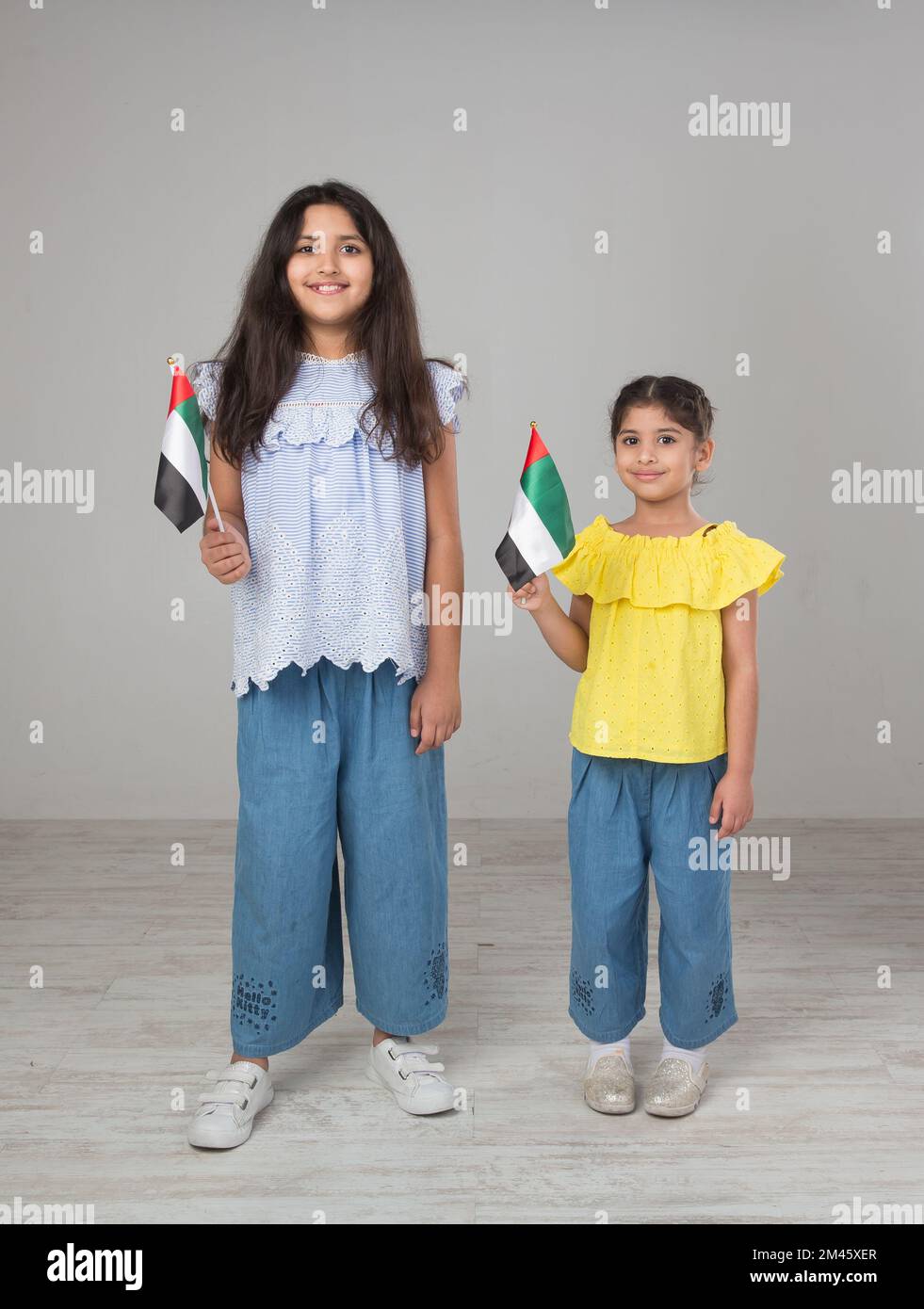 Two girls holding the UAE national flag. Stock Photo