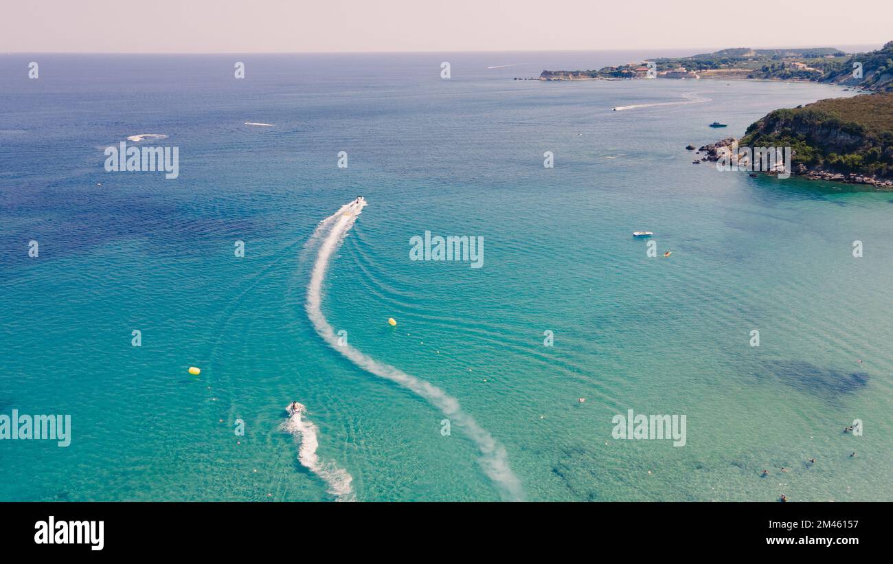 An aerial top view of motor boats leaving water trails on a beautiful ...
