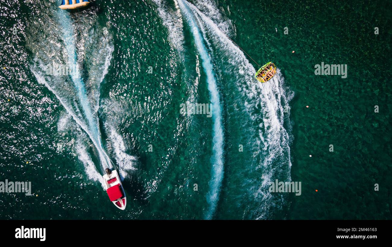 An aerial top view of motor boats leaving water trails on a beautiful ...