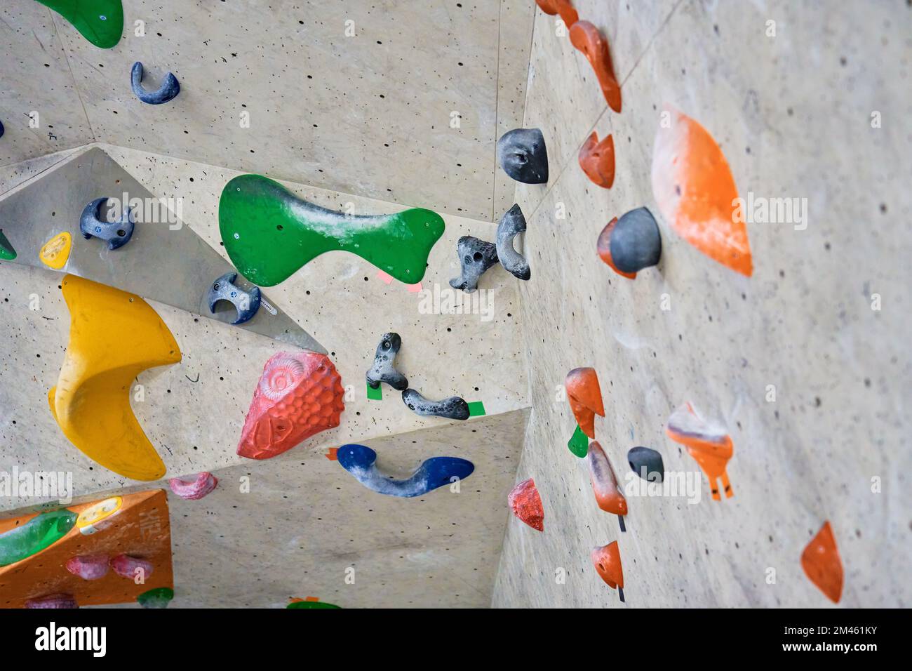 Wall for bouldering in gym with holds for climbing. Active extreme