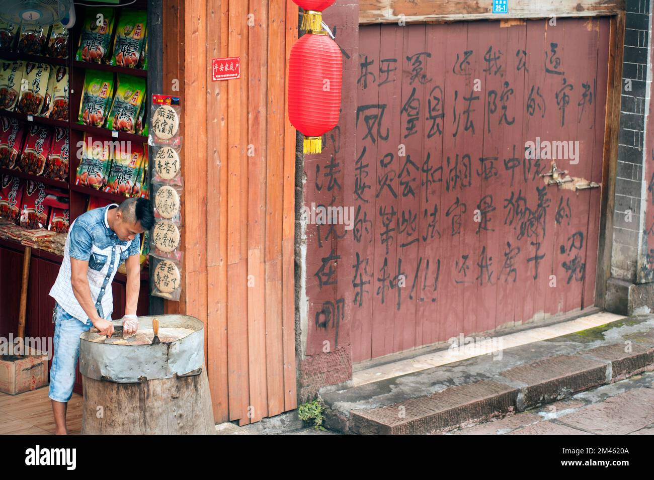 The seller shows that making hit nuts to sheet on shop in Fenghuang old town , China. This ancient town was added to the UNESCO World Heritage.rub Stock Photo