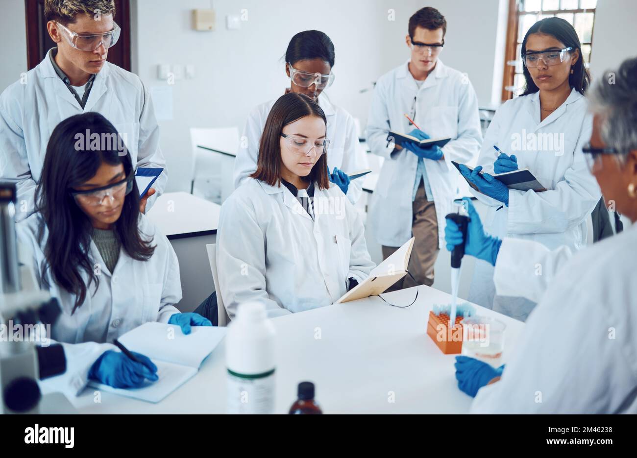 Science, students and education in a medical laboratory writing notes