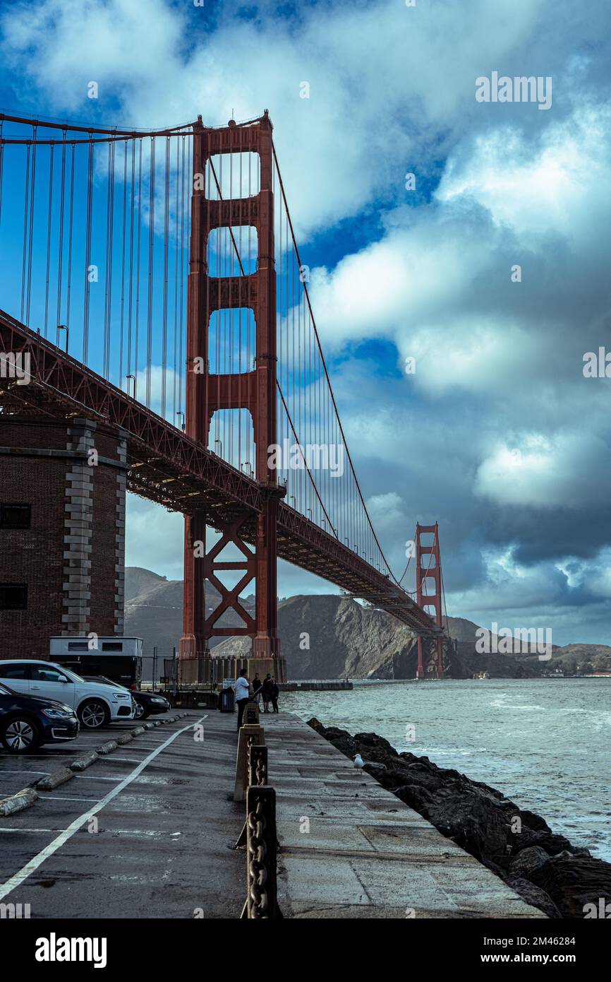 A vertical shot of the cars parked on the pavement under Golden Gate ...