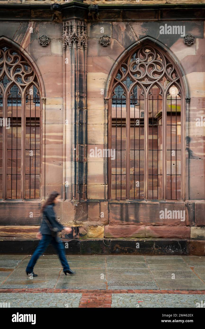 A couple walk in front of the Cathedral of Our Lady of Strasbourg (French: Cathédrale Notre-Dame-De-Strasbourg, German: Liebfrauenmünster zu Straßburg Stock Photo
