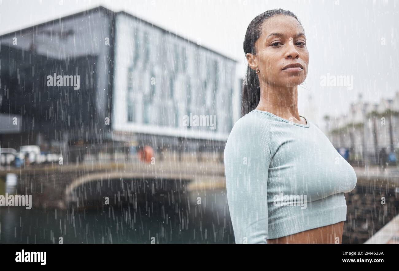 Fitness, motivation and black woman in rain in city for workout, marathon training and running. Sports, winter and portrait of female athlete exercise Stock Photo