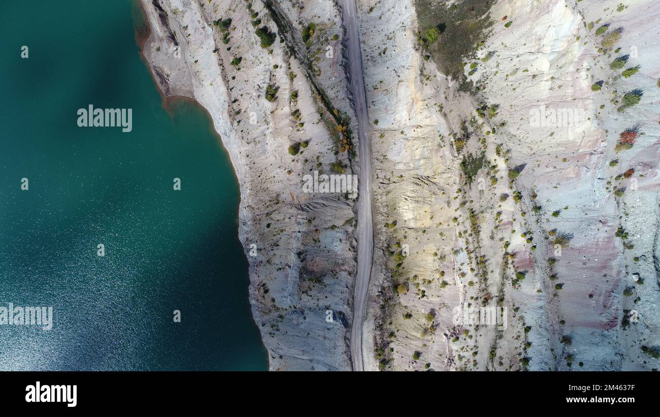 Turquoise water in a mountain forest lake with pine trees. Aerial view ...