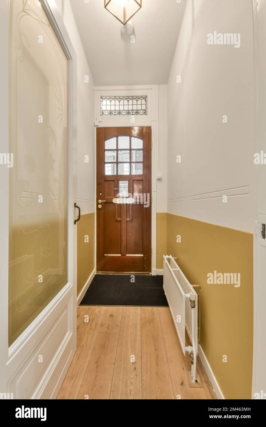 Corridor leading to a residential apartment with a parquet floor and carpet in a cozy house Stock Photo