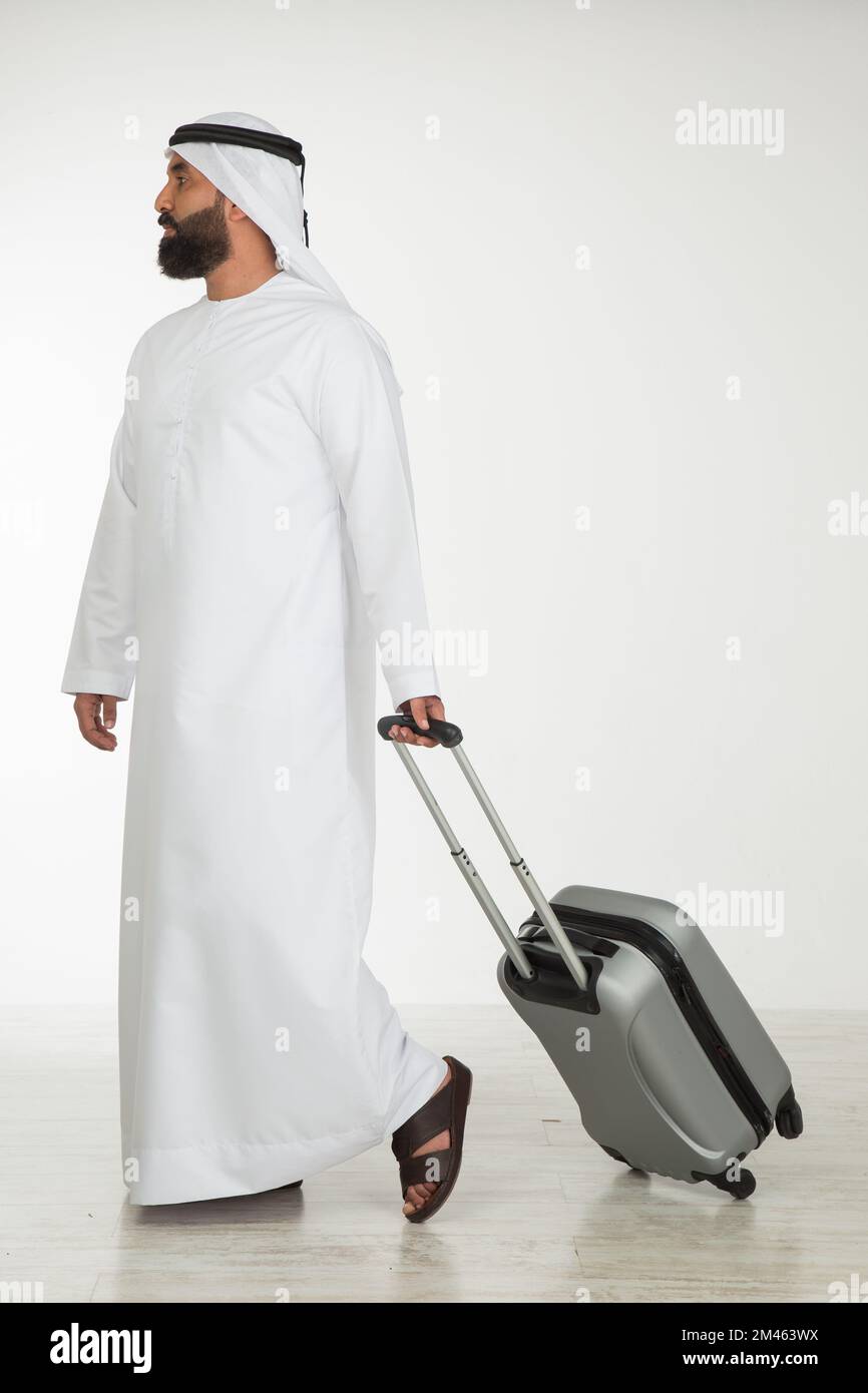 Emirati man carrying a suitcase. Stock Photo