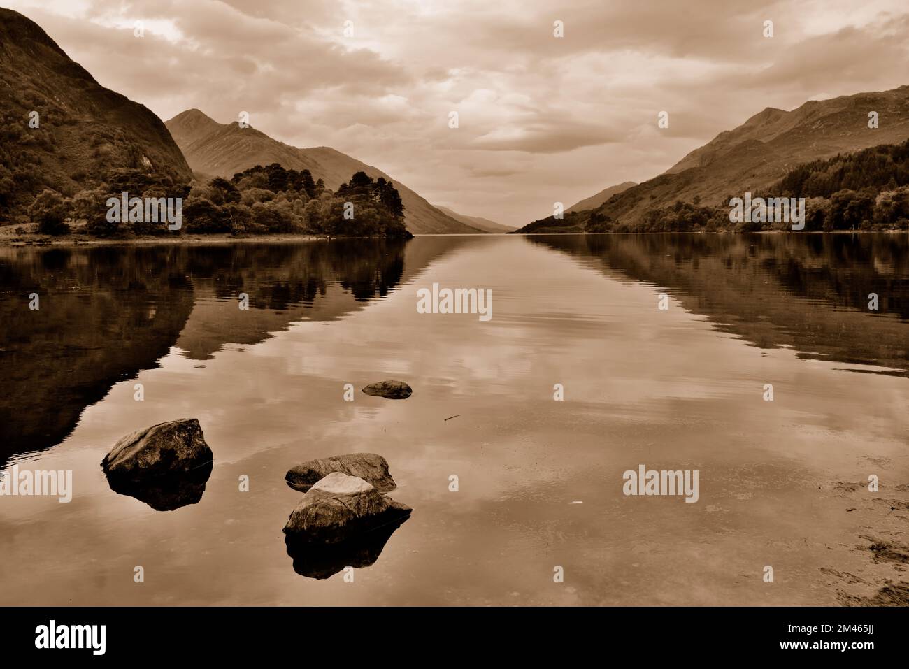 Reflections in Loch Shiel at Glenfinnan in the Scottish Highlands, processed as a sepia image. Stock Photo