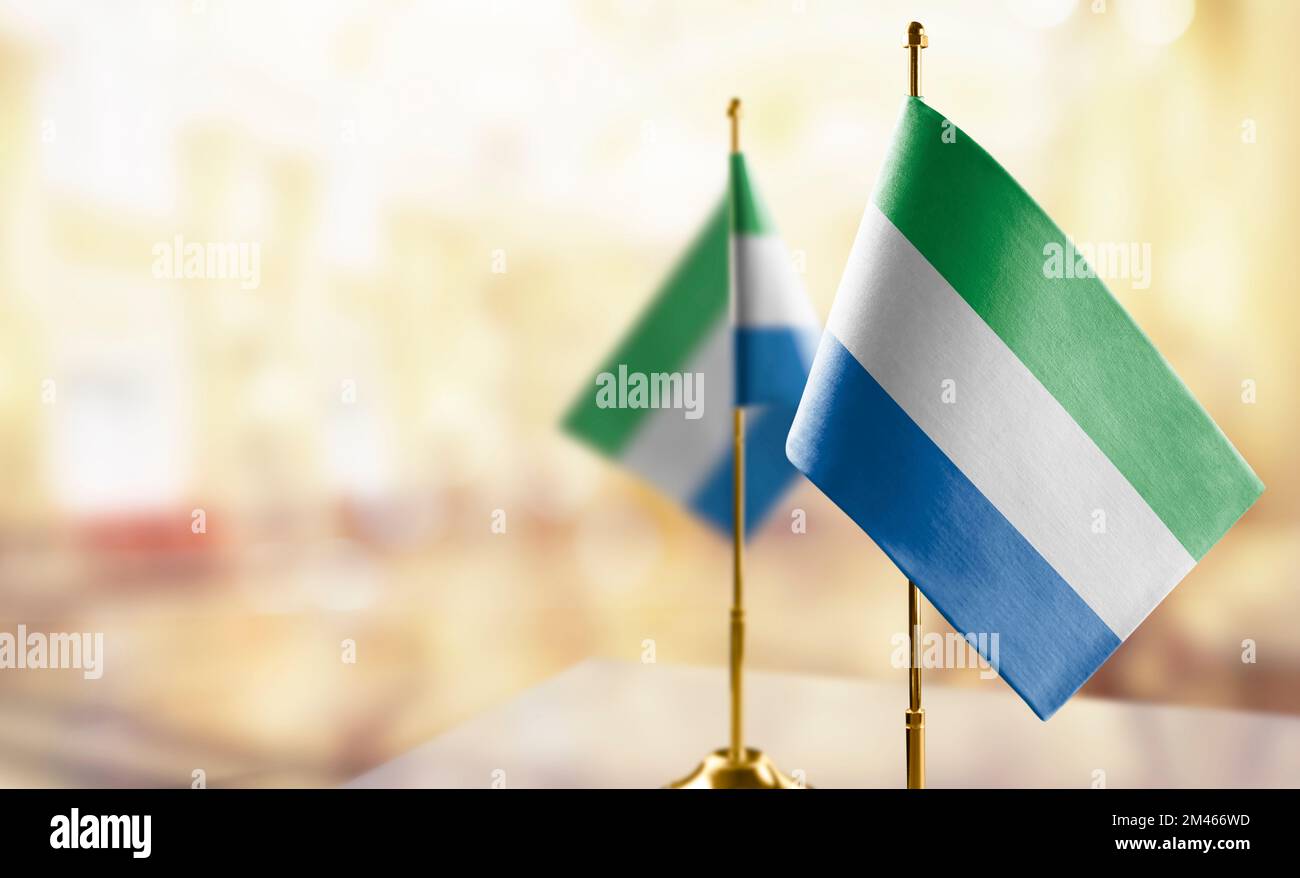 Small flags of the Sierra Leone on an abstract blurry background Stock ...