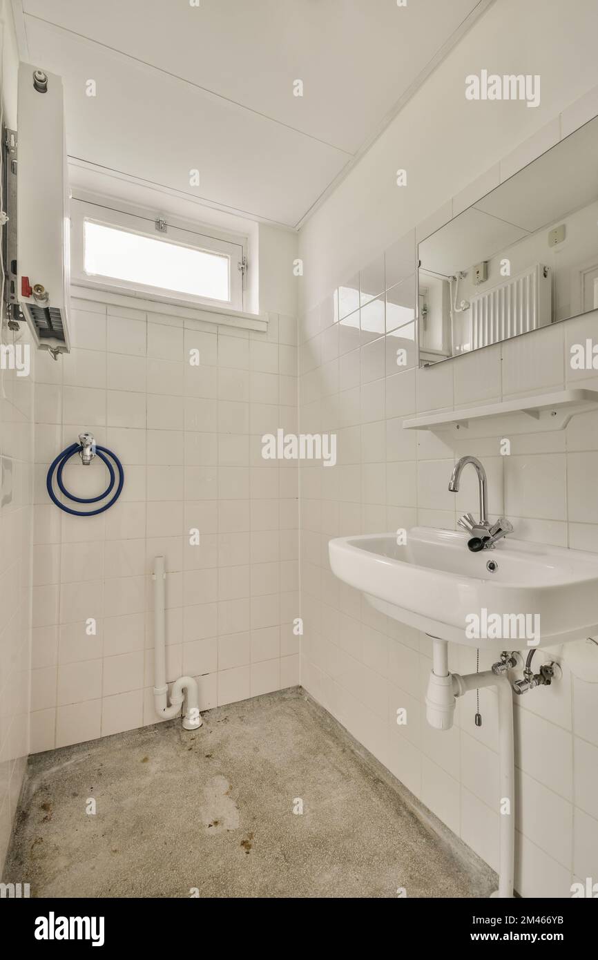 Interior of narrow restroom with sink and flush toilet Stock Photo Alamy