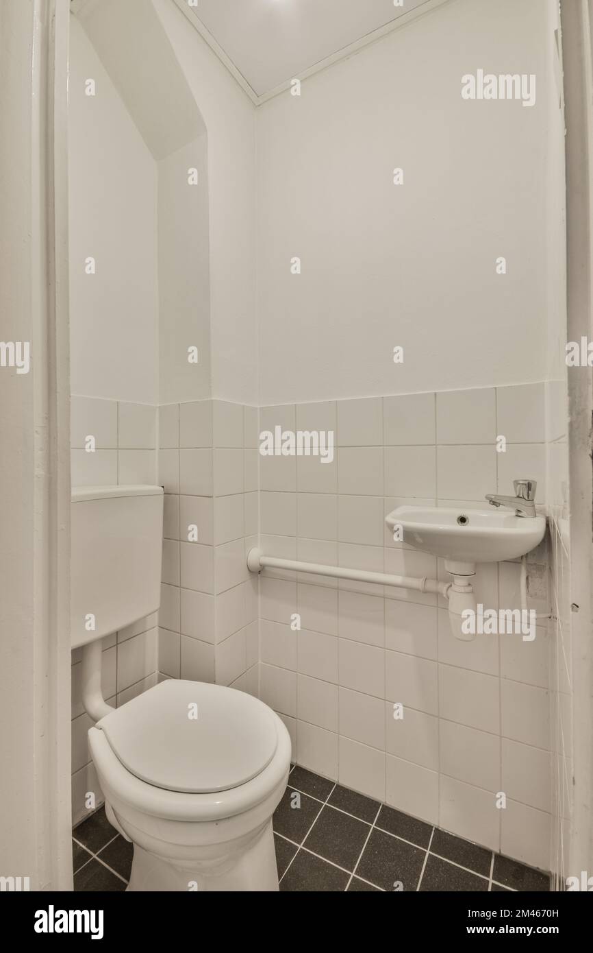 Interior of narrow restroom with sink and flush toilet Stock Photo Alamy