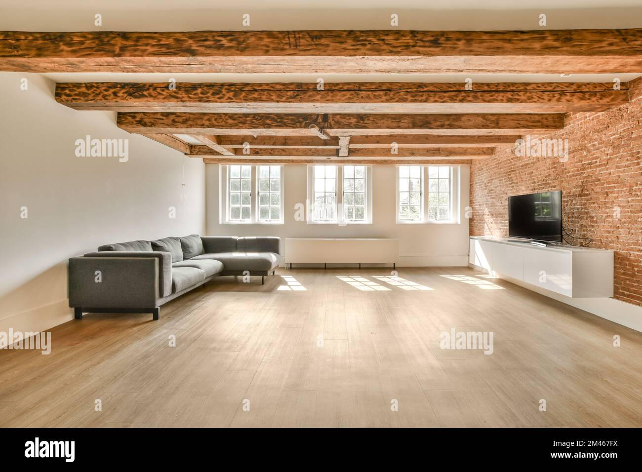 Sofa located near lounge area and kitchen under white ceiling with