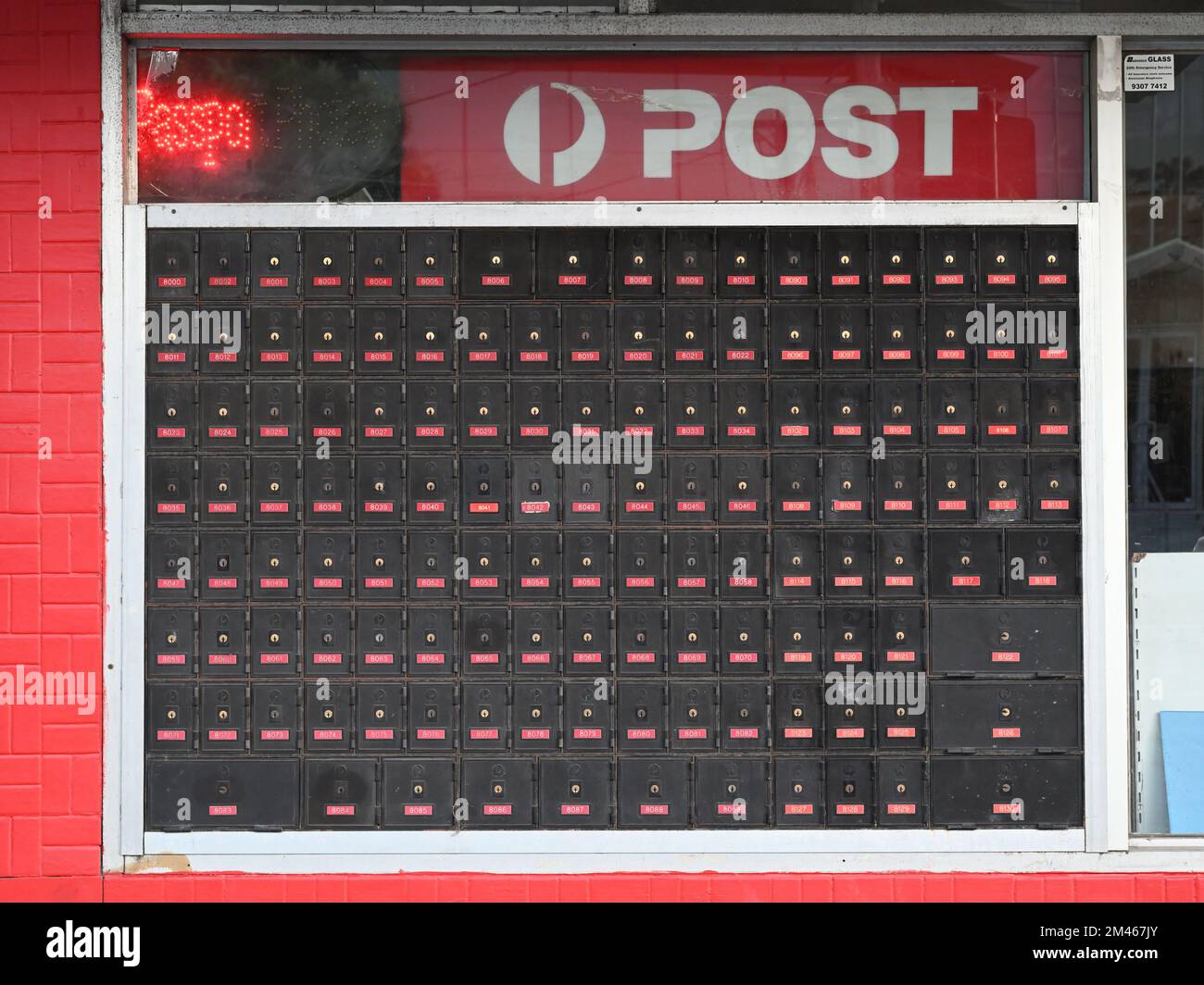 Dirty and faded Australia Post PO boxes outside a shop in the suburbs of Melbourne Stock Photo
