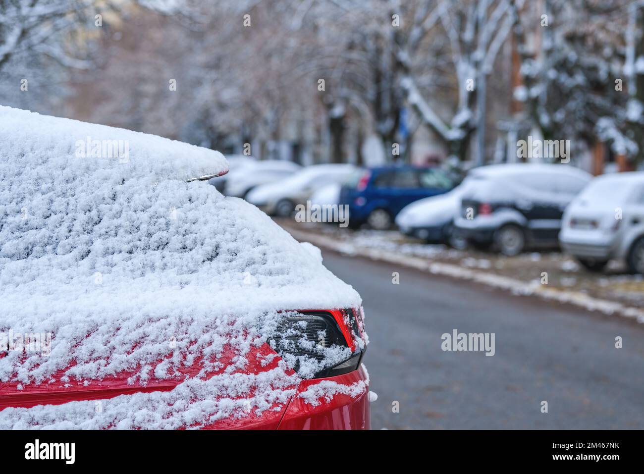Cars under first snow of the winter on parking lot in residential ...