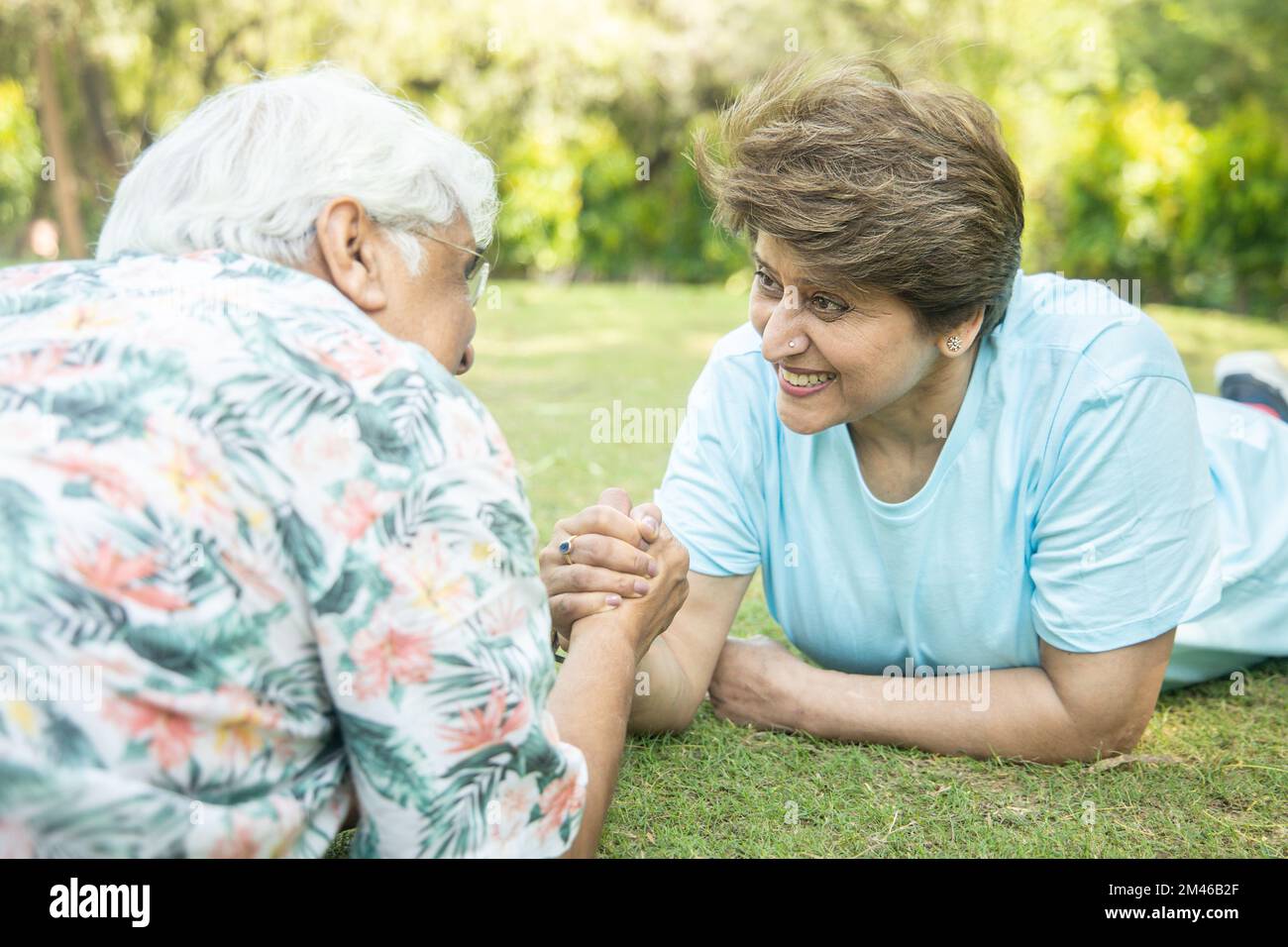 Senior Indian Couple Arm Wrestling Game With Each Other At Park Outdoor