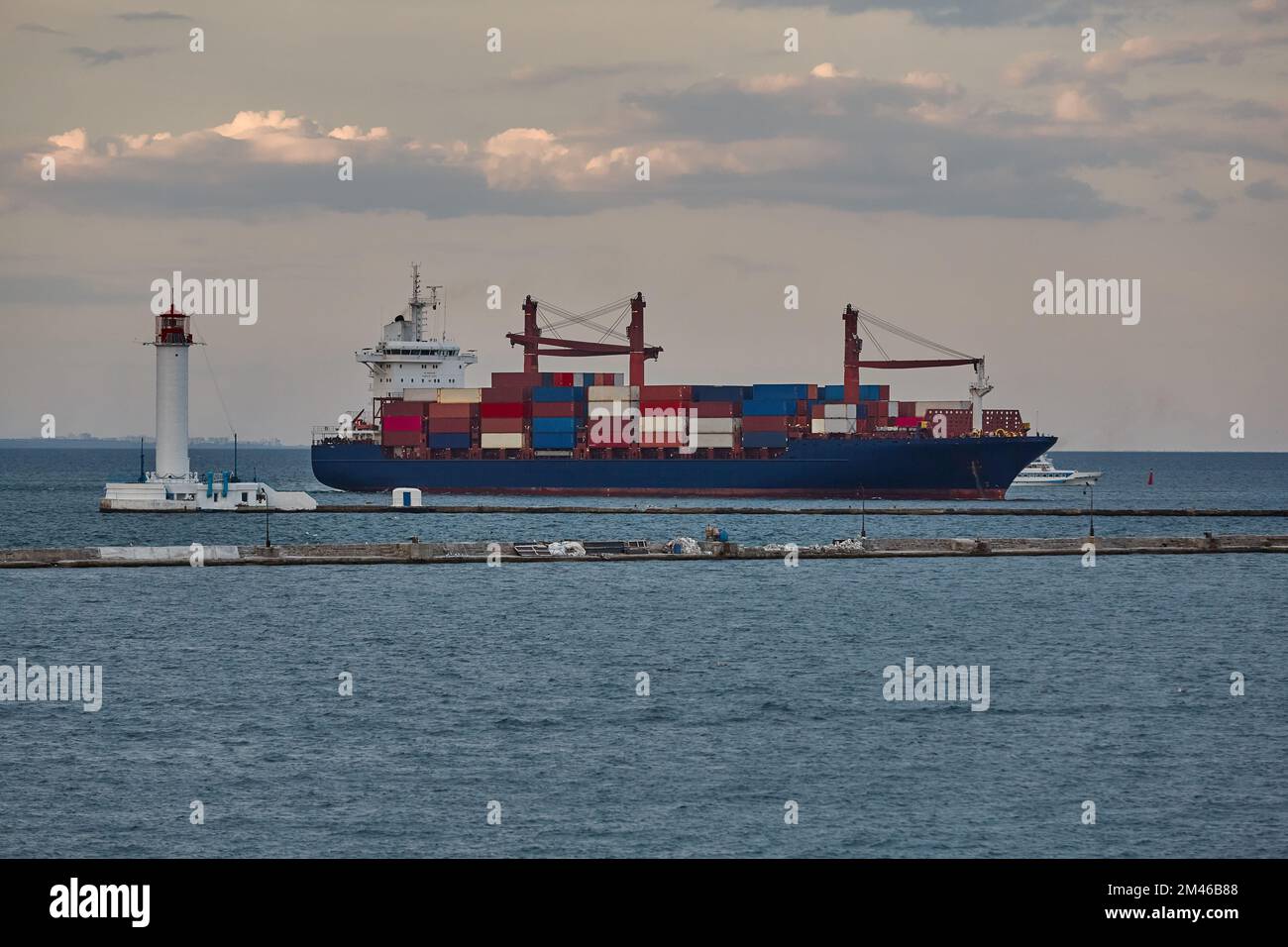 A large merchant ship container vessel in coastal waters of ocean. A merchant ship is moving around sea in daytime Stock Photo
