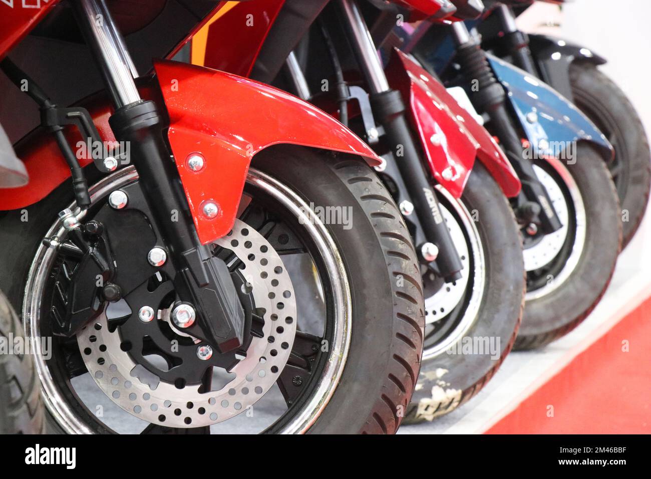 A Group of electric scooters lined up with a view of its front wheel and its braking systems Stock Photo