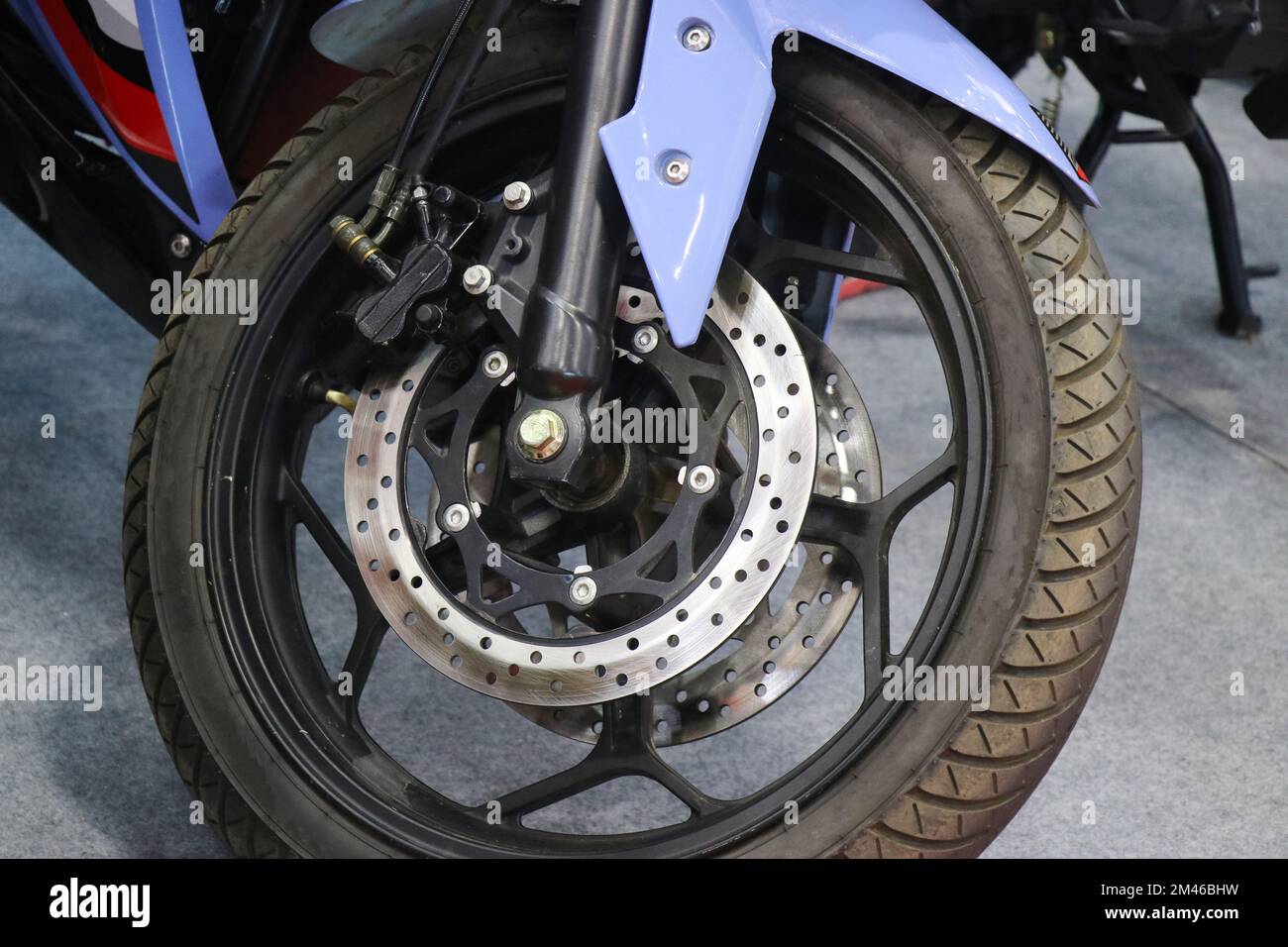 Front wheel of an electric motorbike with stylish alloy wheels and twin