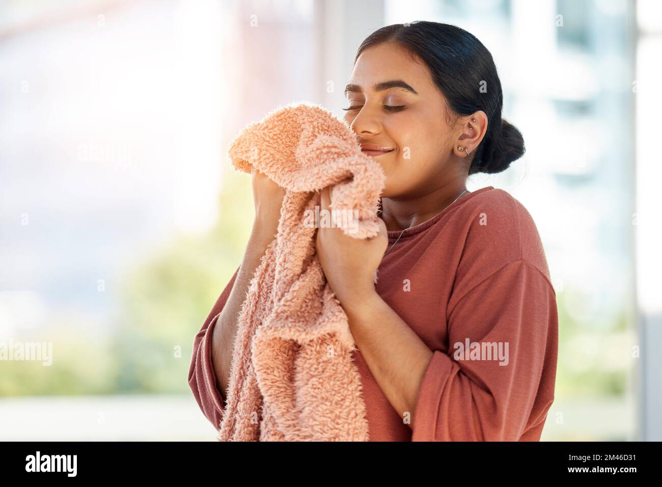 Woman smelling clean laundry, blanket or fabric for fresh and clean