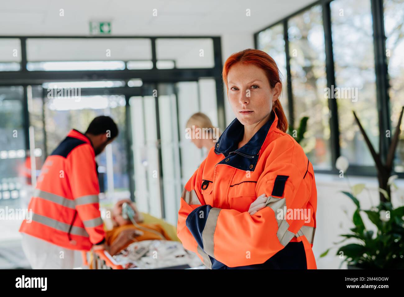 Portrait of rescuer woman, her colleagues taking care of patient from ...