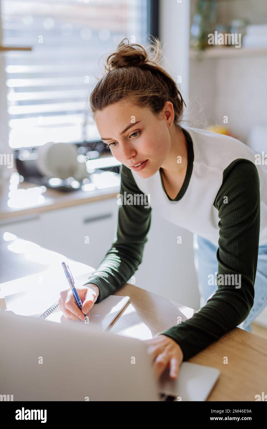Young woman having homeoffice in her kitchen. Stock Photo